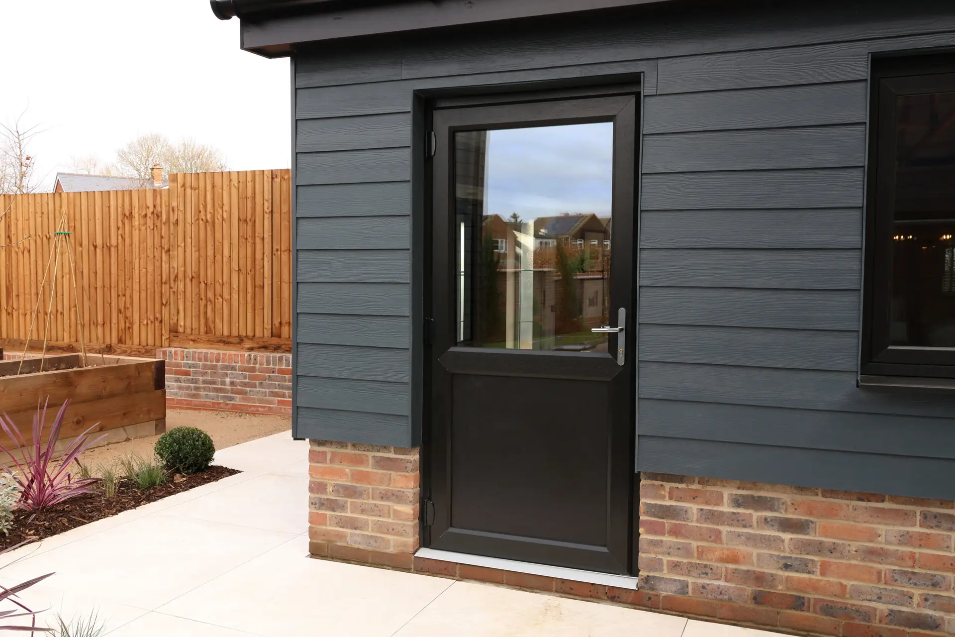 uPVC entrance door on a wood-clad new build